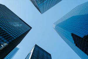 Faible angle de hautes tours d'affaires avec des fenêtres en verre miroir situées dans la mégalopole du centre-ville contre le ciel bleu